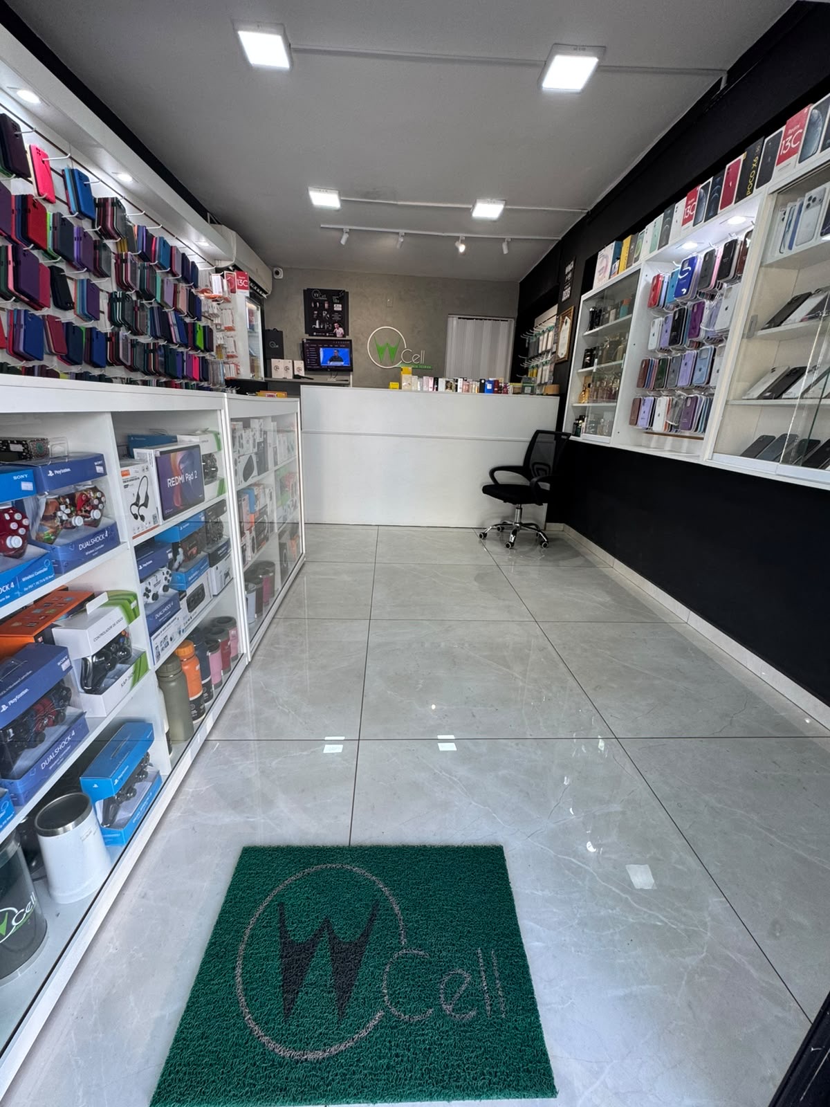 Loja WCell Assistência Técnica em Jacarezinho — PR: iPhone, Xiaomi, capinhas, películas e acessórios expostos nas prateleiras